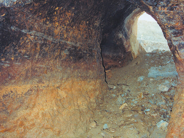 Galerie antique mise à jour lors de l’exploitation de la mine à ciel ouvert des Fouilloux. On remarque sur les parois des galeries les traces noires résultant de l’abattage au feu.